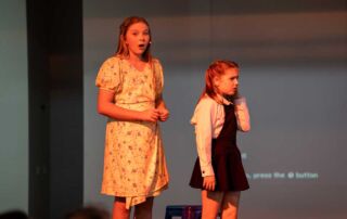 Students performing Matilda Jnr, The Musical on stage.